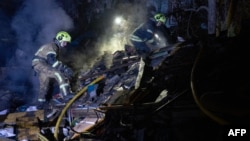 Pompierii ucraineni intervin la locul unui atac cu rachete rusești la Kiev, în seara zilei de 21 octombrie 2026.