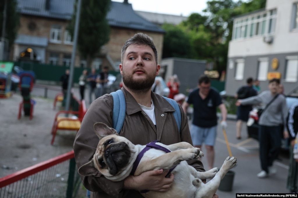 Banorët e Kievit qëndrojnë jashtë një shtëpie të dëmtuar nga sulmi rus, në mëngjesin e 6 qershorit.