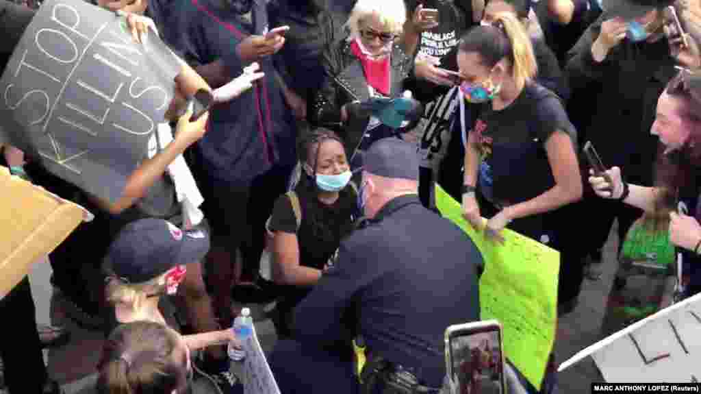 Oakley police chief Eric Christensen talks with a protester as he takes a knee with protesters demonstrating against the death of George Floyd in Minneapolis, in Oakley, California, U.S. in this still picture obtained from May 31, 2020 social media video. 