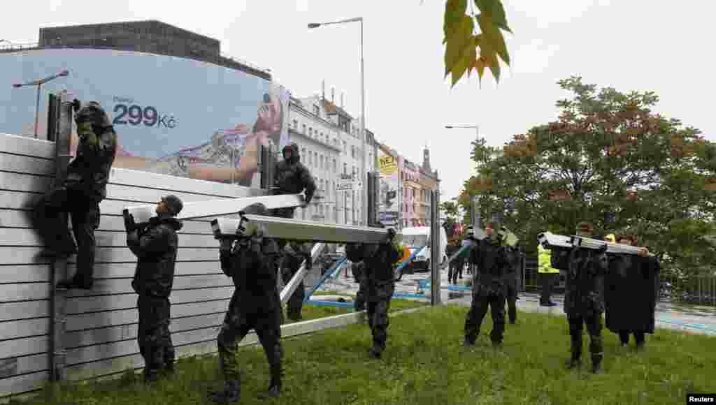 Czech soldiers erect metal barriers on the bank of the Vltava River in Prague.