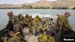 Kazakh troops in an amphibious vehicle while crossing the Ili river during military exercises outside Almaty in August 2010
