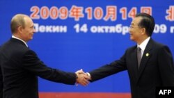 Chinese Prime Minister Wen Jiabao (right) greets his Russian counterpart Vladimir Putin at a welcoming ceremony ahead of the SCO summit in Beijing.