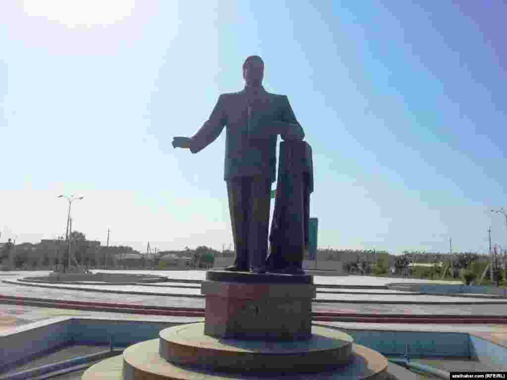 Türkmenabat şäherinde Saparmyrat Nyýazowyň elinde "Ruhnamany" saklap duran heýkeli.