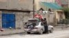 A man fills his car with personal belongings as families leave insecure neighborhoods in the flashpoint city of Fallujah. 