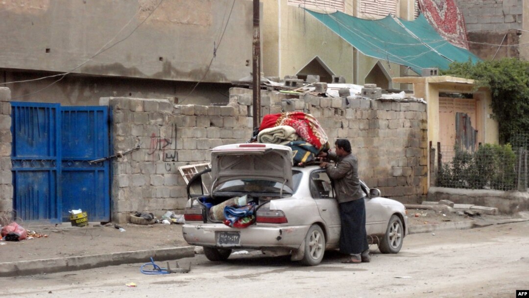 A man fills his car with personal belongings as families leave insecure neighborhoods in the flashpoint city of Fallujah. 