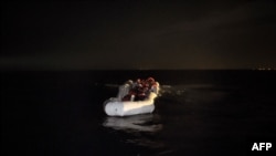 Беженцы и мигранты в лодке у берегов Ливии. 