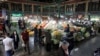 People, some wearing protective face masks, grocers stalls displaying produce at the Tajrish Bazaar in Tehran, March 12, 2020