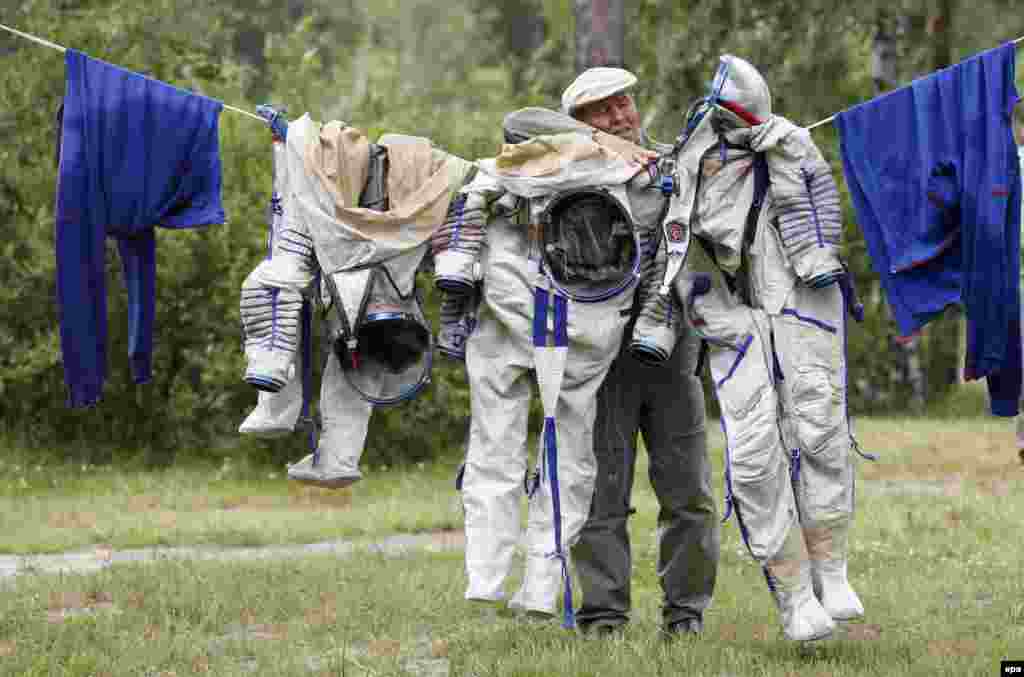 An engineer of the Russian Cosmonaut Training Center hangs out to dry the pressure suits of the members of the Expedition 48/49 to the International Space Station after their water-landing simulation during preflight training in Noginsk, Russia. (epa/Maxim Shipenkov)