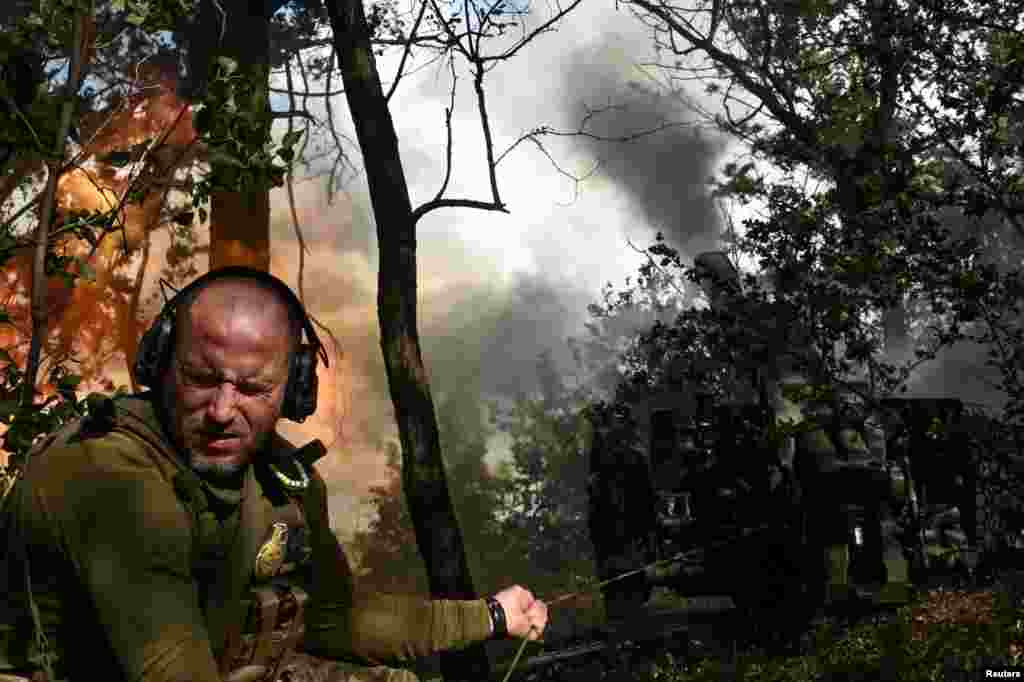 A Ukrainian soldier fires a howitzer toward Russian troops at the front line in Ukraine's Zaporizhzhya region
