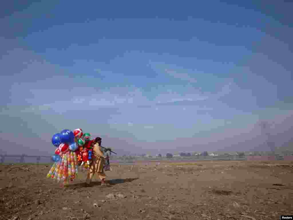 A man carries balloons for sale near the banks of the Ravi River in Lahore, Pakistan, on November 14. (REUTERS/Mohsin Raza)