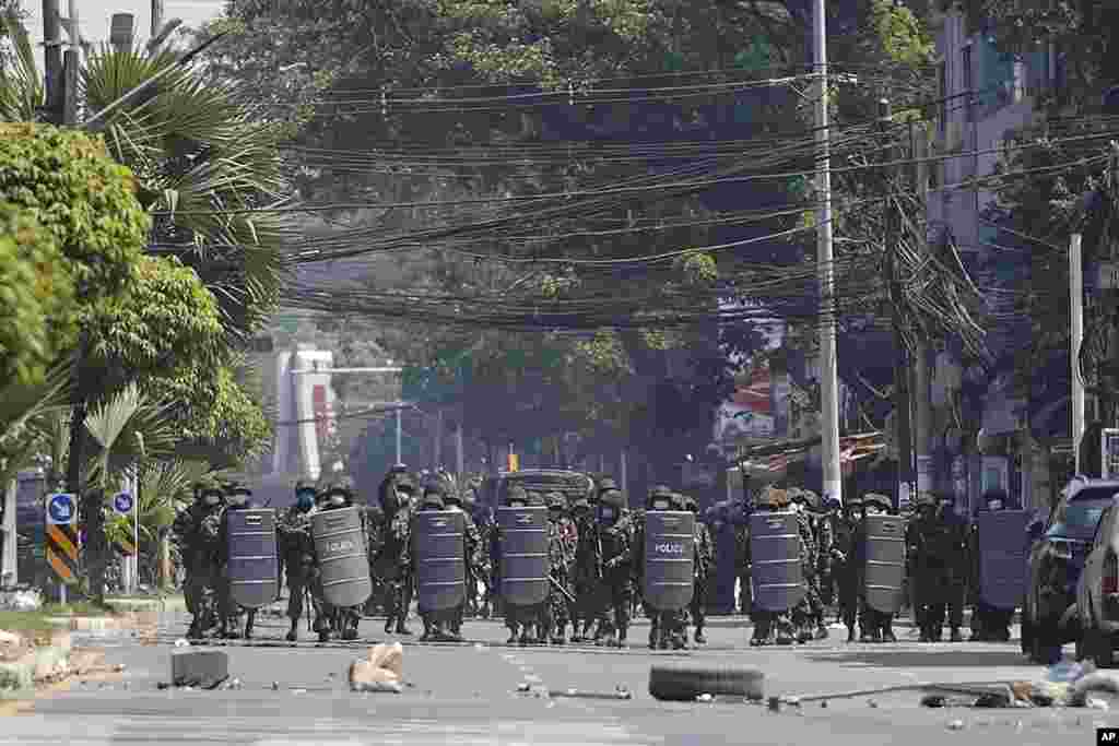 Myanmar military with shields move forward during a protest against the military coup in Yangon, Myanmar, Tuesday, March 2, 2021.