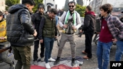 Syrians step on a regime flag as they celebrate near the Clock Tower in the central city of Homs on December 8.