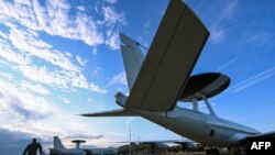 Un membru al echipajului verifică o aeronavă NATO Airborne Warning and Control System (AWACS), care participă la exercițiul multinațional Air Defender 23 condus de germani, la baza militară din Geilenkirchen, din vestul Germaniei - 20 iunie 2023.