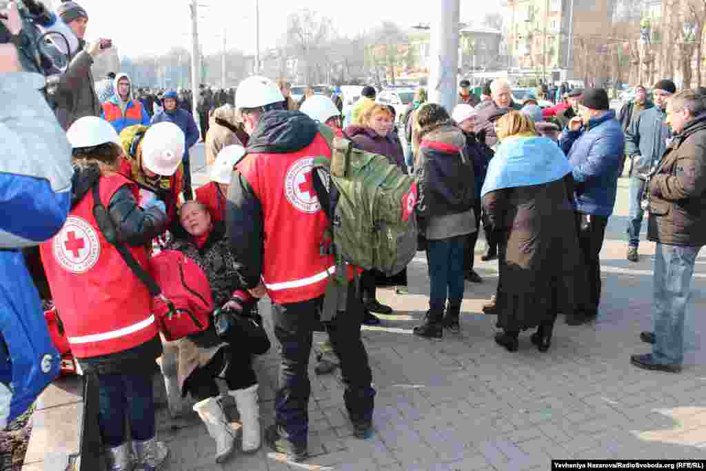 Жінку оглядають волонтери загону швидкого реагування Червоного Хреста у Запоріжжі. З місця події її забрала швидка з підозрою на перелом ноги