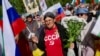 Жена с тениска с надпис "СССР", букет цветя и руско знаме участва в отбелязването на руския Ден на победата в София, 9 май 2025 г.