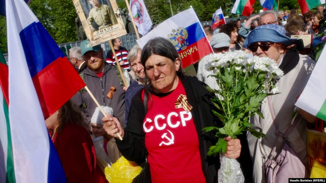Жена с тениска с надпис "СССР", букет цветя и руско знаме участва в отбелязването на руския Ден на победата в София, 9 май 2025 г.