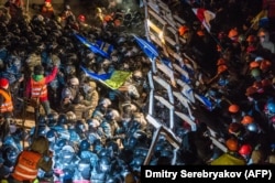 Сотрудники подразделения "Беркут" берут штурмом баррикады антиправительственных демонстрантов. Киев, 11 декабря 2013 года.