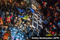 Riot police storm a barricade erected by protesters on Independence Square late on December 11. The demonstrators refused to leave and resisted the police in a tense standoff. Berkut riot police and Interior Ministry special forces moved against the protesters at around 2 a.m., prompting then-U.S. Secretary of State John Kerry to express "disgust" over the crackdown.