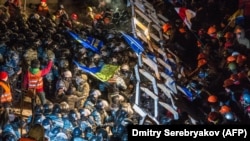 Policajci su nasrnuli na barikadu koju su demonstranti podigli na Trgu nezavisnosti kasno 11. decembra. Demonstranti su odbili da napuste Trg i usprotivili su se policiji u napetom obračunu. Policijska jedinica Berkut i specijalne snage Ministarstva unutarnjih poslova krenule su protiv demonstranata oko dva ujutro, potakavši tadašnjeg državnog sekretara Sjedinjenih Država Džona Kerija (John Kerry) da izrazi „zgražavanje” zbog nasilja.