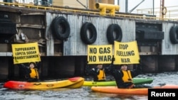 Greenpeace activists hold signs as they block a Russian gas shipment from being offloaded in Tornio, Finland, on September 17.