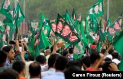 Supporters of former Pakistani Prime Minister Nawaz Sharif crowd around his car as his convoy leaves Islamabad on August 9.