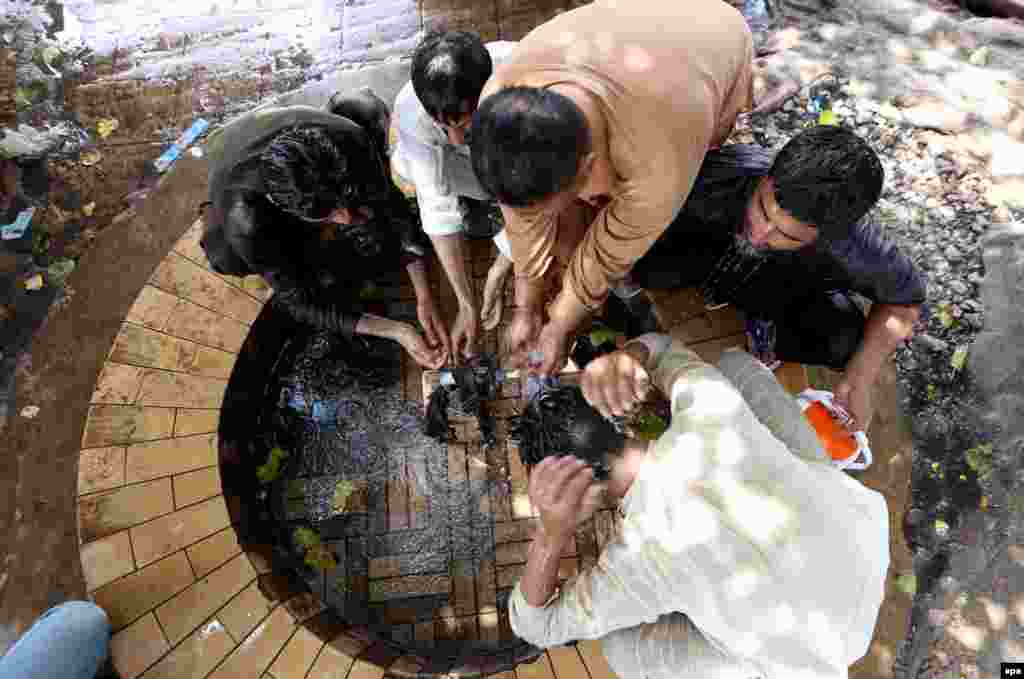 People cool off on a hot day in Karachi.