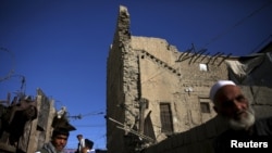 Afghanistan -- file -- A man carries his belongings from a partially damaged house, after an earthquake in the old quarters of Kabul, Afghanistan October 26, 2015.