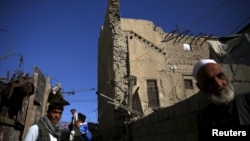 FILE: A man carries his belongings from a partially damaged house, after an earthquake in the old quarters of Kabul, Afghanistan in October 2015.