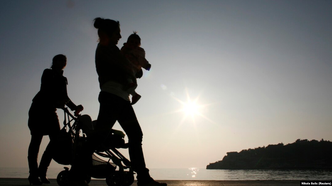 Femei care își plimbă copiii după ce se întorc de la muncă