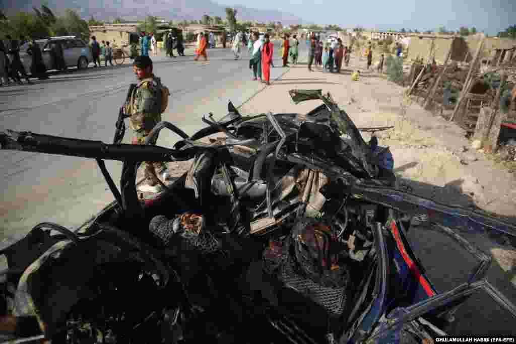 Afghan security officials inspect the scene of a roadside bomb that killed six civilians on the outskirts of Jalalabad on July 21.