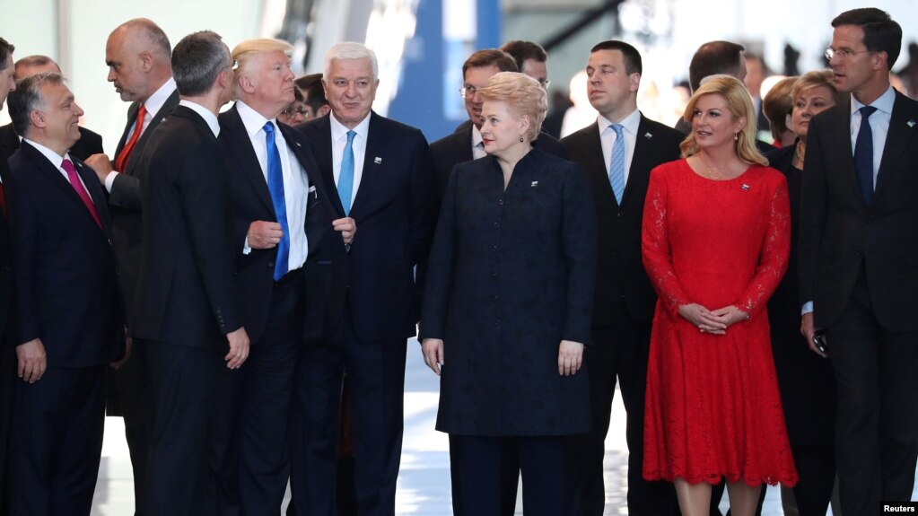 U.S. President Donald Trump adjusts his jacket after pushing past Montenegro Prime Minister Dusko Markovic at the NATO summit