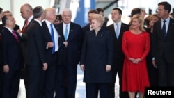 U.S. President Donald Trump adjusts his jacket after pushing past Montenegro Prime Minister Dusko Markovic at the NATO summit