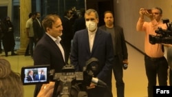 Majid Taheri (left) speaks to reporters after his return to Iran on June 8. 