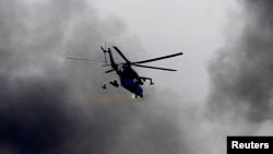 A Ukrainian Mi-24 gunship fires its cannons at rebels at the main terminal building of Donetsk airport on May 26.