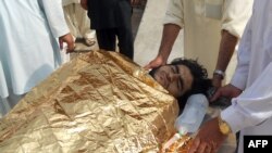 Pakistan -- Men carry an injured bombing victim into a hospital in Kohat, October 3, 2013