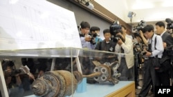 Cameramen take footage of torpedo parts salvaged from the Yellow Sea during a press conference at the Defense Ministry in Seoul on May 20.