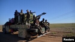 Iraqi-backed militia gather in the desert of Anbar as they prepare to depart for Mosul to fight against Islamic State (IS). The battle to retake the northern Iraqi city from IS has seen increasingly intense fighting in recent weeks.