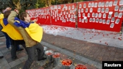 Активисты в Киеве бросают помидоры в портреты депутатов, не пришедших на голосование по антикоррупционным законам