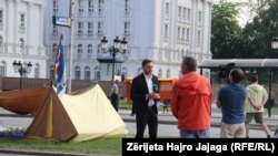Люди в палаточном лагере перед зданием правительства во время антиправительственных протестов в Скопье. 18 мая 2015 года.