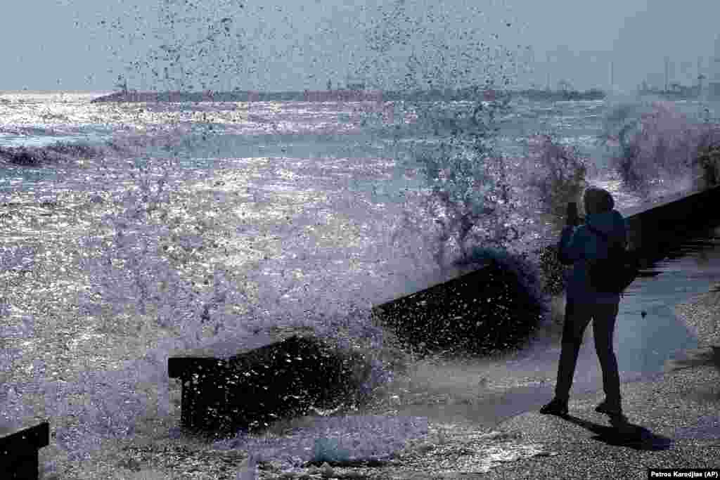 A woman takes photos of the sea in the southern coastal city of Larnaca, Cyprus.&nbsp;