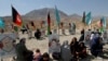 Afghan families gather at the graves of their relatives, adorned with their pictures on the outskirts of Kabul, on September 14.