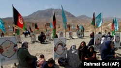 Afghan families gather at the graves of their relatives, adorned with their pictures on the outskirts of Kabul, on September 14.