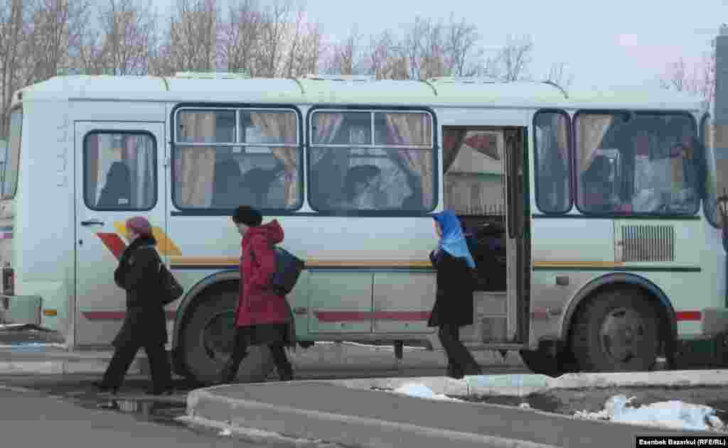 "Избиратели" выходят из автобуса и направляются к избирательному участку. Астана, 3 апреля 2011 года.