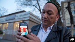 Гражданин Казахстана этнический казах из Китая Омир Бекалы, который провел под стражей в Китае восемь месяцев, показывает на мобильном телефоне фото своих родителей, предположительно оказавшихся в заключении в Китае. 