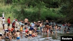 Migranți care se îndreaptă în caravană spre SUA, prin Mexic, într-un popas pe malul unui râu, la Mapastepec, la 29 decembrie 2023 (REUTERS/Jose Torres)