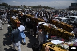 Supporters carry coffins containing the remains of King Habibullah Kalakani and his companions during the reburIal ceremony for the late monarch in Kabul on September 1.
