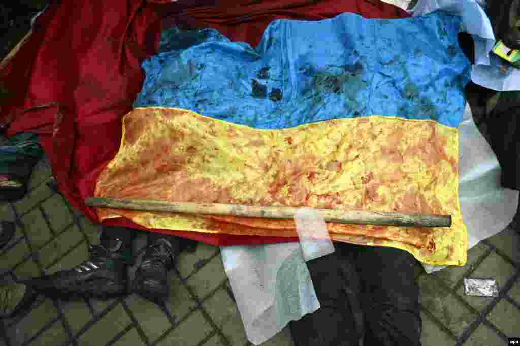 Kiyev 20 fevral. Toqquşma qurbanlarından birinin meyidi qanlı Ukrayna bayrağı ilə örtülüb