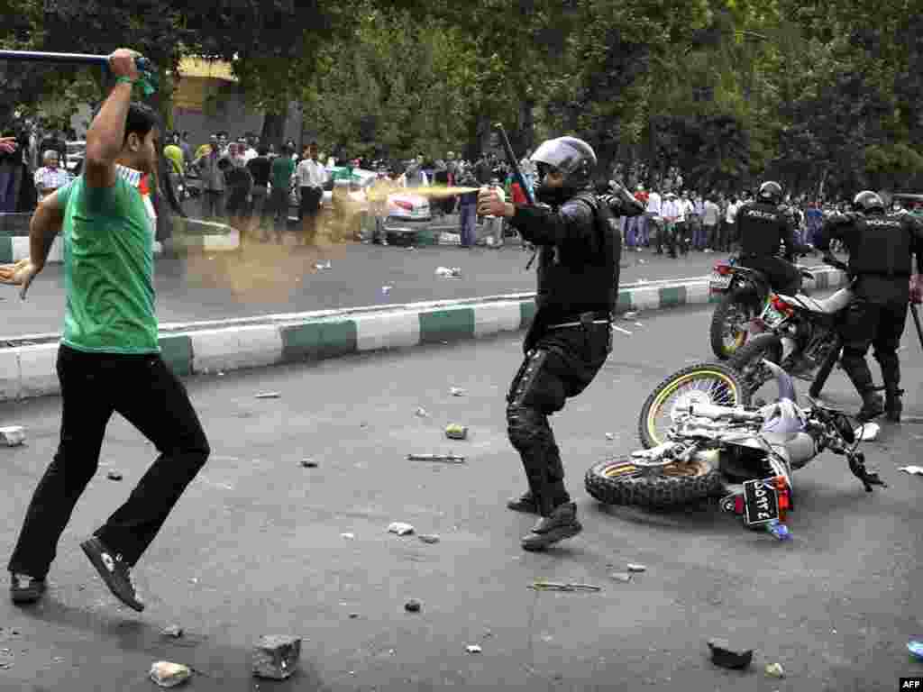 An Iranian police officer sprays tear gas at a supporter of defeated Iranian presidential candidate Mir Hossein Musavi during riots in Tehran on June 13.