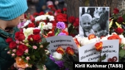 Цветы у фото погибших в сгоревшем торговом центре, Кемерово 
