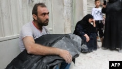 A Syrian man carries the body of his nephew following a reported air strike in Aleppo on September 23.